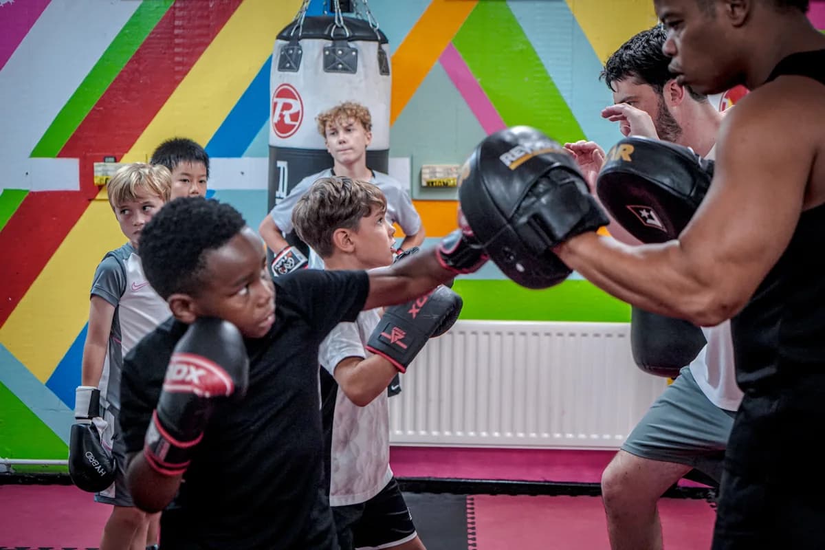 A young participant practising with focus mitts